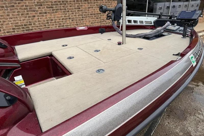 Slide: The Image of 2008 Ranger 188 VX boat with beige deck and maroon trim, parked near brick wall. - 3