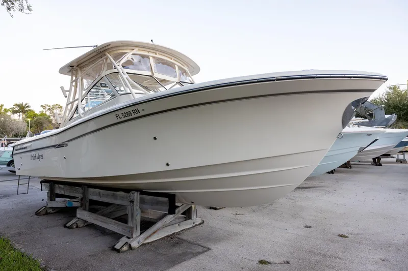 The Image of 2018 Grady-White Freedom 285 boat on display, elevated on wooden supports. - 1