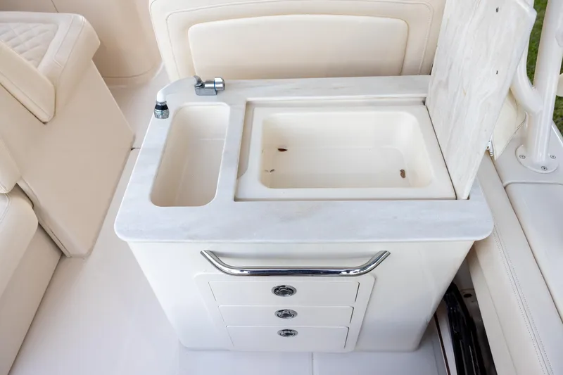 Slide: The Image of 2018 Grady-White Freedom 285 boat sink and storage area with faucet and drawers. - 10
