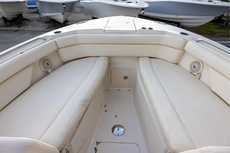 Slide: The Image of 2018 Grady-White Freedom 285 boat interior with white cushioned seating and speakers. - 17