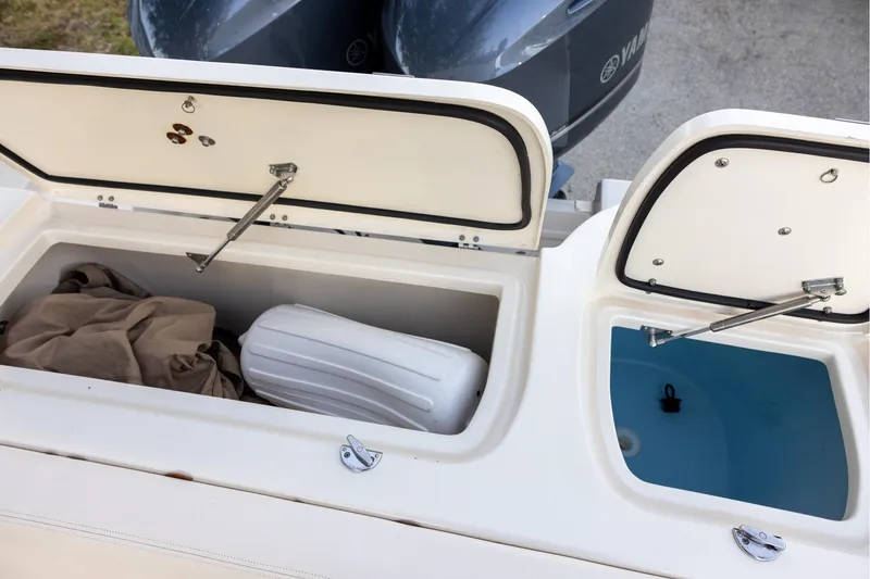 Slide: The Image of 2018 Grady-White Freedom 285 boat storage compartments with open lids and visible contents. - 20