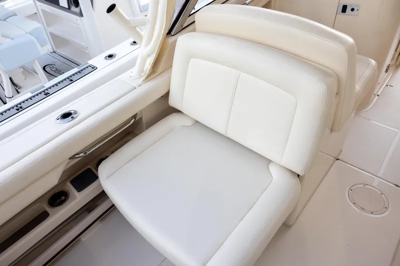 Slide: The Image of 2018 Grady-White Freedom 285 boat interior with white seating and rod holders. - 9