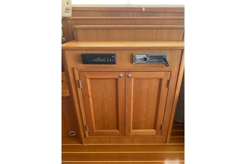 Slide: The Image of Wooden cabinet with audio controls on a 2010 Sabre 38 Express boat. - 12
