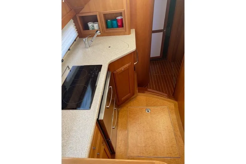 Slide: The Image of 2010 Sabre 38 Express yacht interior kitchen with modern appliances and wooden cabinetry. - 14