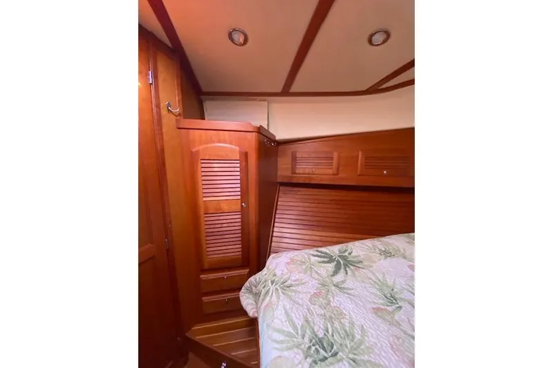 Slide: The Image of 2010 Sabre 38 Express cabin interior with wooden paneling and floral bedding. - 27