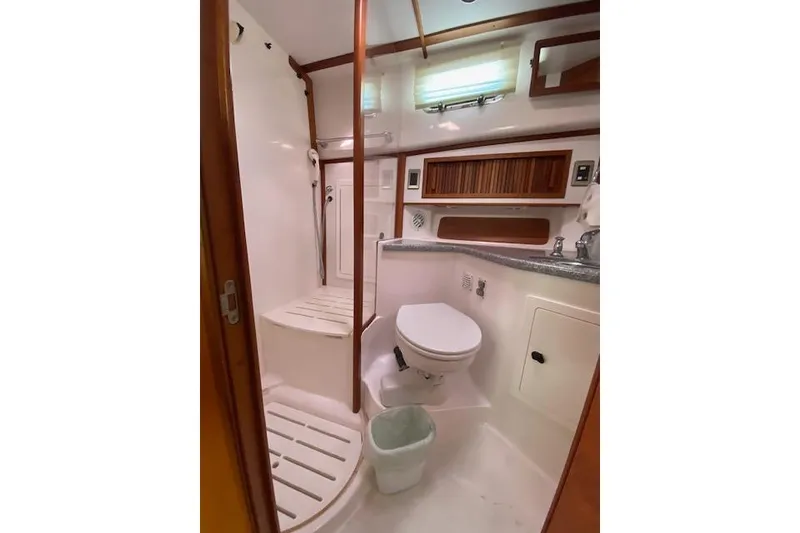 Slide: The Image of 2010 Sabre 38 Express yacht bathroom with shower, toilet, and wooden accents. - 36