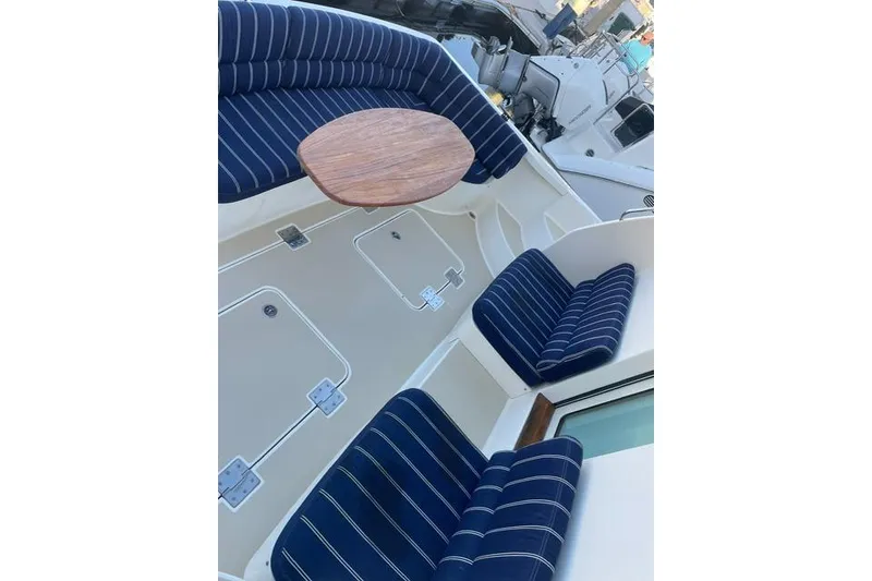 Slide: The Image of 2010 Sabre 40 Sedan boat with blue-striped seating and wooden table. - 55