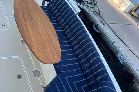 Slide: The Image of 2010 Sabre 40 Sedan boat with striped seating and wooden table on deck. - 56