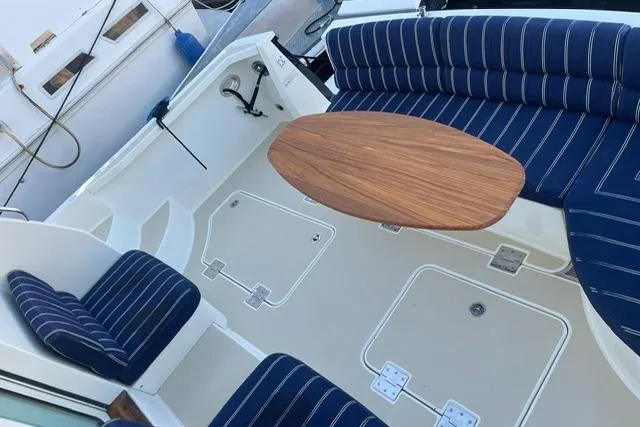 Slide: The Image of 2010 Sabre 40 Sedan boat interior with striped seating and wooden table. - 57