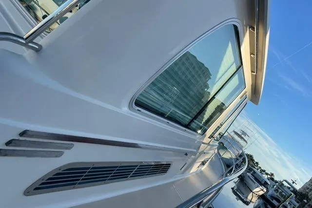 Slide: The Image of 2010 Sabre 40 Sedan yacht side view with sleek design and reflective windows. - 58