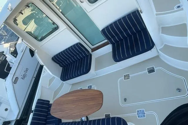 Slide: The Image of 2010 Sabre 40 Sedan boat deck with striped seating and wooden table. - 62