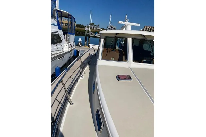 Slide: The Image of 2010 Sabre 40 Sedan yacht docked, showcasing sleek design and spacious deck. - 70