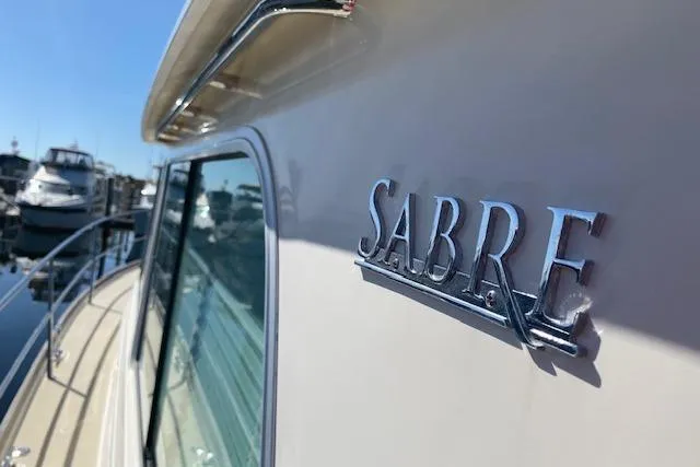 Slide: The Image of 2010 Sabre 40 Sedan yacht docked at marina, showcasing sleek design and branding. - 72