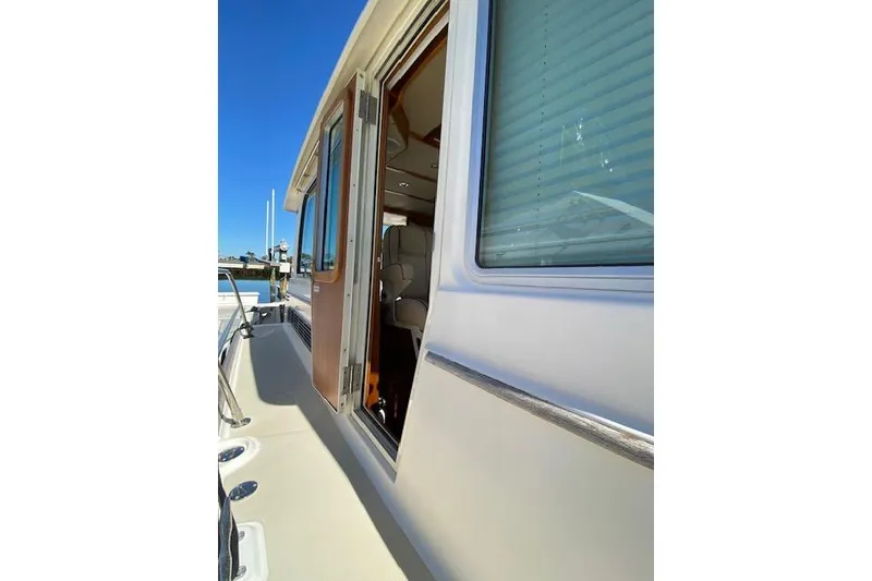 Slide: The Image of 2010 Sabre 40 Sedan yacht exterior with open cabin door and clear blue sky. - 79