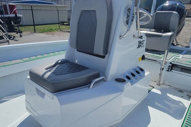 Slide: The Image of 2024 Xpress H22B Bay boat interior with gray seating and console details. - 14