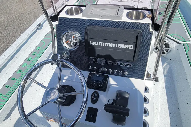 Slide: The Image of 2024 Xpress H22B Bay boat dashboard with steering wheel and Humminbird electronics. - 16