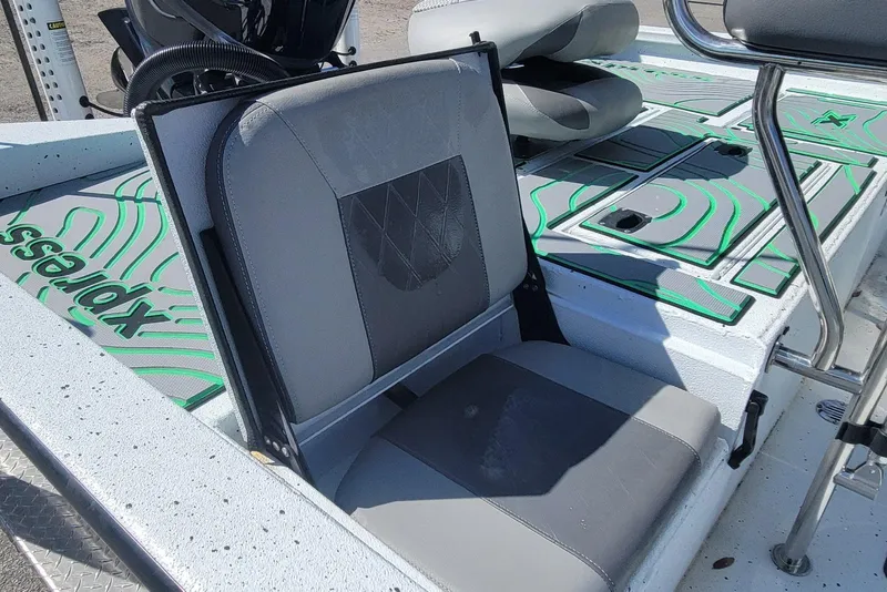 Slide: The Image of 2024 Xpress H22B Bay boat interior with gray seating and green accents. - 21