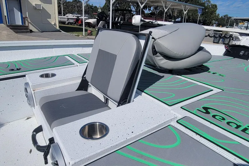 Slide: The Image of 2024 Xpress H22B Bay boat interior with gray seating and cup holders. - 22
