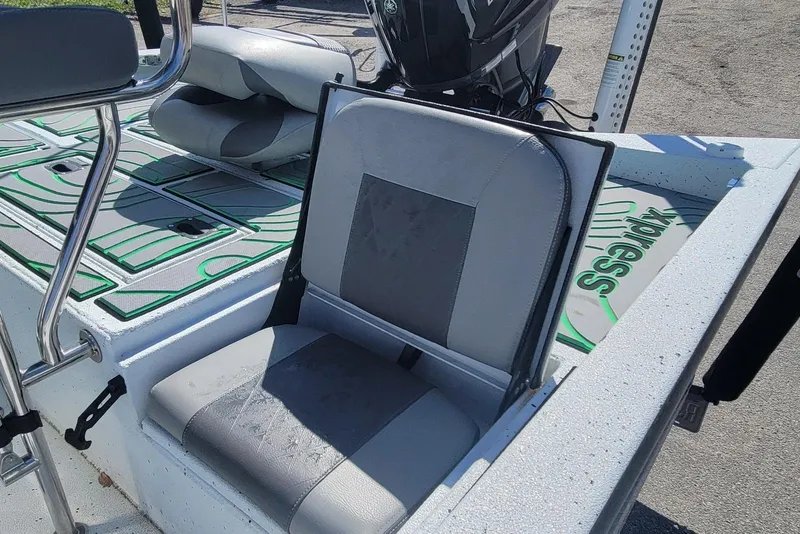 Slide: The Image of 2024 Xpress H22B Bay boat with cushioned seating and motor, showcasing modern design. - 23