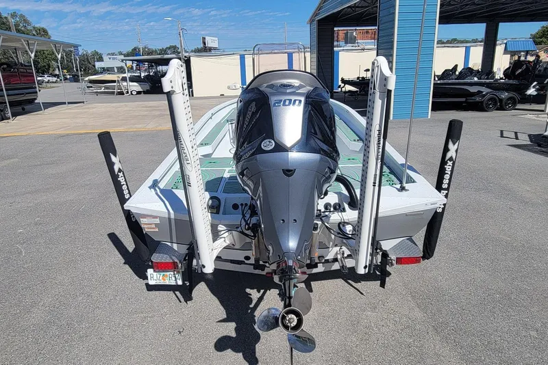 Slide: The Image of 2024 Xpress H22B Bay boat with powerful outboard motor, parked in a marina. - 3