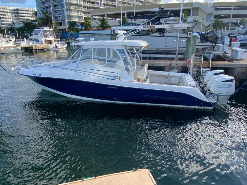 Slide: The Image of 2006 Hydra-Sports Vector 3300 VX boat docked at marina with twin Suzuki engines. - 2
