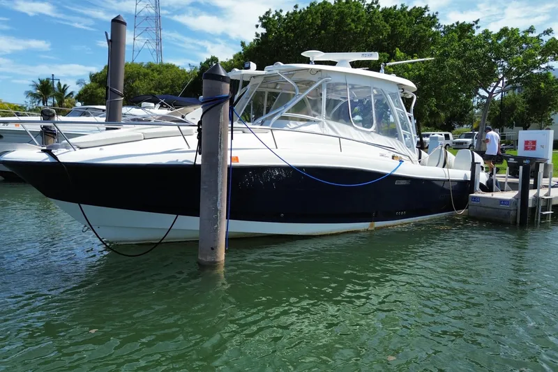 Slide: The Image of 2006 Hydra-Sports Vector 3300 VX boat docked in a marina, surrounded by water and trees. - 1