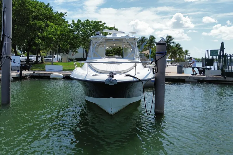 Slide: The Image of 2006 Hydra-Sports Vector 3300 VX docked at marina, surrounded by lush greenery and clear skies. - 4