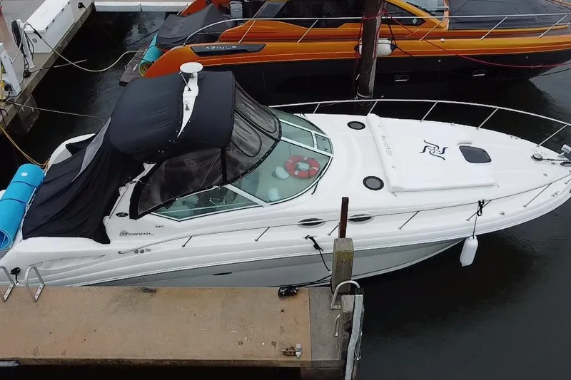 The Image of 2004 Sea Ray 340 Sundancer docked, featuring sleek design and black canopy. - 0