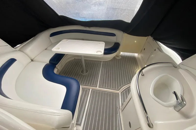 Slide: The Image of 2004 Sea Ray 340 Sundancer interior with seating, table, and sink in a cozy cabin. - 17