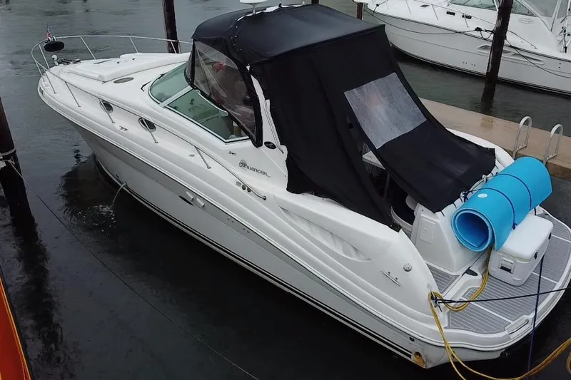 Slide: The Image of 2004 Sea Ray 340 Sundancer yacht docked, featuring a black canopy and white hull. - 23