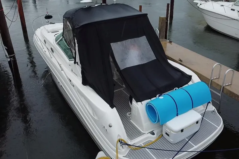 Slide: The Image of 2004 Sea Ray 340 Sundancer docked with black canopy and blue floatation mat. - 25