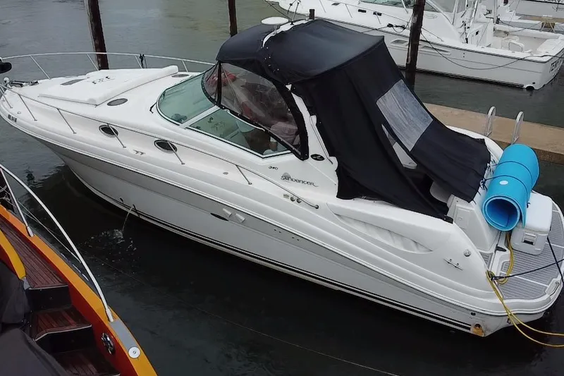 Slide: The Image of 2004 Sea Ray 340 Sundancer boat docked with black canopy and blue fender. - 26