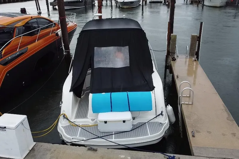 Slide: The Image of 2004 Sea Ray 340 Sundancer docked, covered with black canopy, adjacent to orange boat. - 27