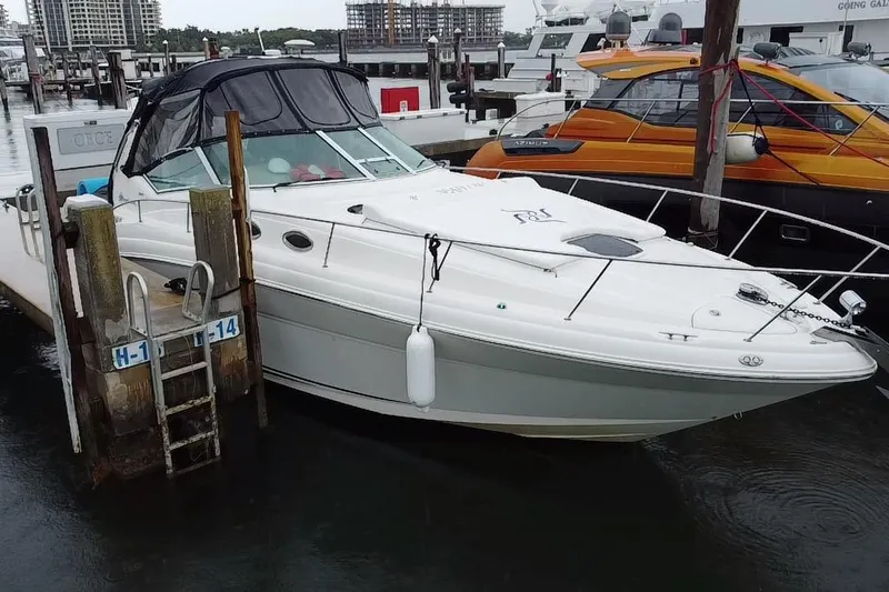 Slide: The Image of 2004 Sea Ray 340 Sundancer docked at marina, featuring sleek design and white exterior. - 3