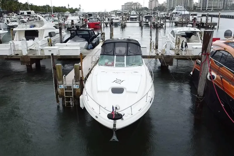 Slide: The Image of 2004 Sea Ray 340 Sundancer docked at a marina, surrounded by other boats. - 4