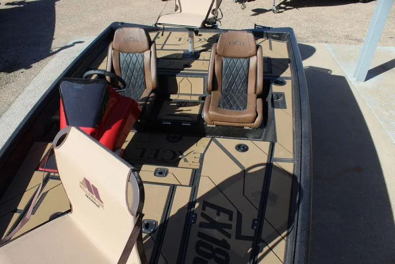 Slide: The Image of 2026 Excel EX 183 boat interior with brown seats and steering console. - 14