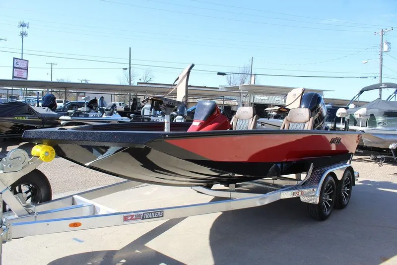 Slide: The Image of 2026 Excel EX 183 boat on trailer, red and black design, parked outdoors. - 8