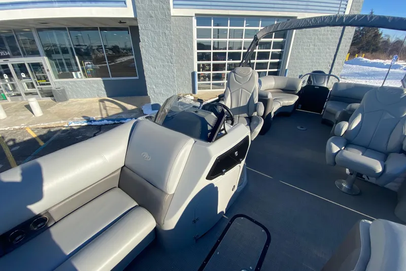 Slide: The Image of 2022 Manitou 25 OASIS RF SHP pontoon boat interior with plush seating and helm. - 13