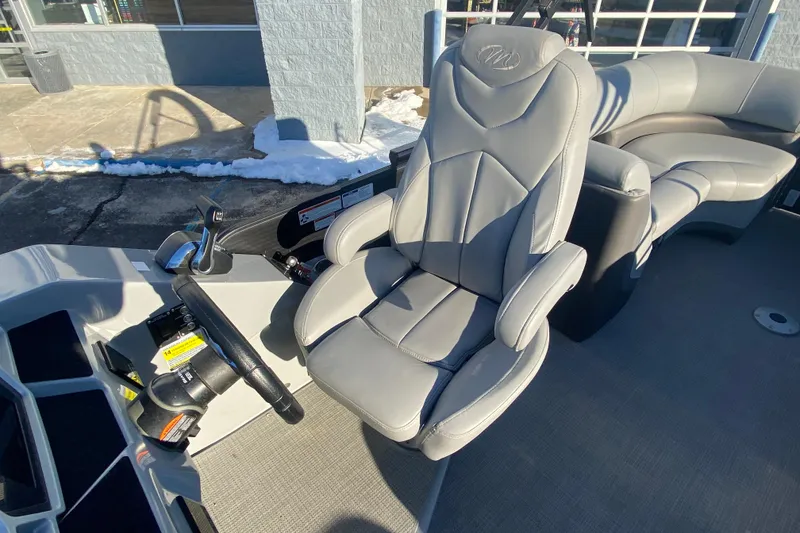 Slide: The Image of 2022 Manitou 25 OASIS RF SHP boat interior with gray captain's chair and controls. - 16