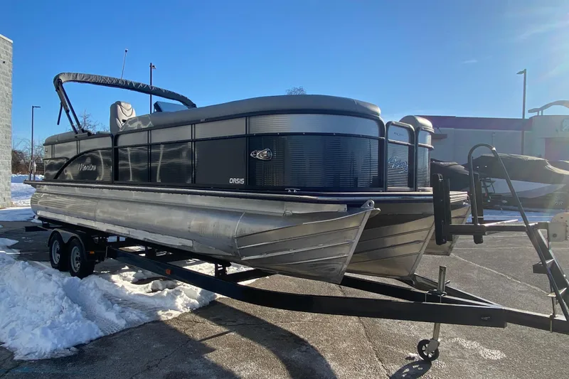 Slide: The Image of 2022 Manitou 25 OASIS RF SHP pontoon boat on trailer, parked in snowy lot. - 8