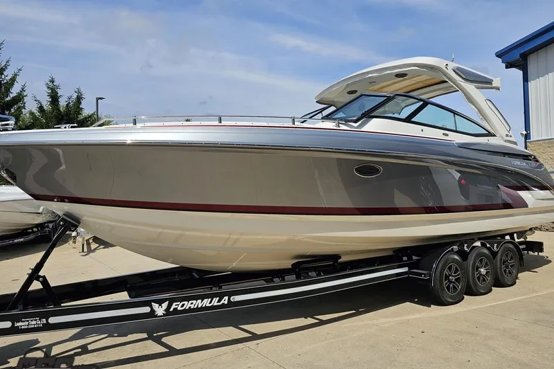 Slide: The Image of 2020 Formula 330 Crossover Bowrider on trailer, sleek design, parked outdoors. - 17