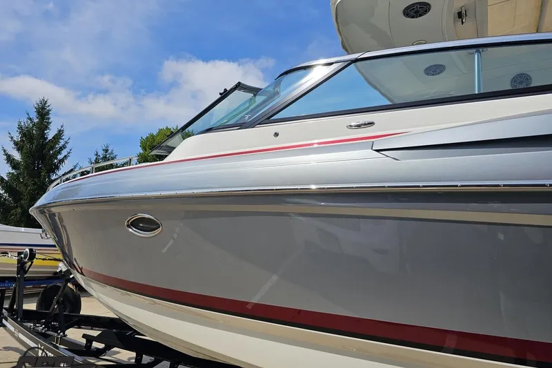 Slide: The Image of 2020 Formula 330 Crossover Bowrider boat on trailer, sleek design, sunny day. - 24