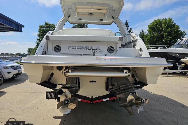 Slide: The Image of 2020 Formula 330 Crossover Bowrider boat, rear view with dual propellers, parked outdoors. - 29