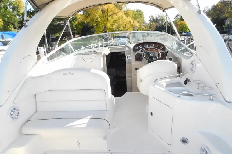 Slide: The Image of 2001 Sea Ray Sundancer 280 interior with helm, seating, and dashboard in a marina setting. - 10