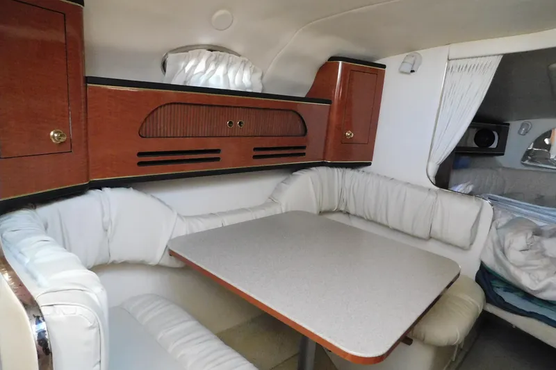 Slide: The Image of Interior of 2001 Sea Ray Sundancer 280, featuring a cozy dining area with cushioned seating. - 17