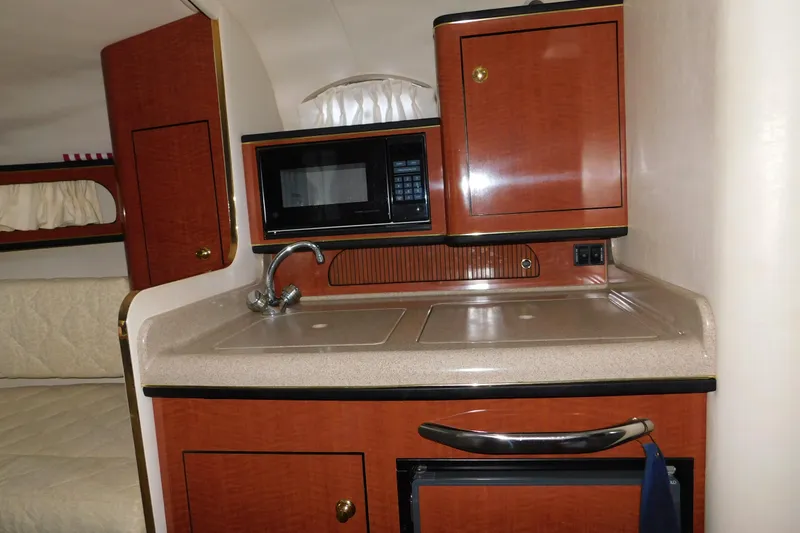 Slide: The Image of 2001 Sea Ray Sundancer 280 interior kitchen with sink, microwave, and cabinetry. - 18