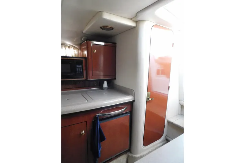 Slide: The Image of 2001 Sea Ray Sundancer 280 interior with kitchenette and wooden cabinetry. - 22