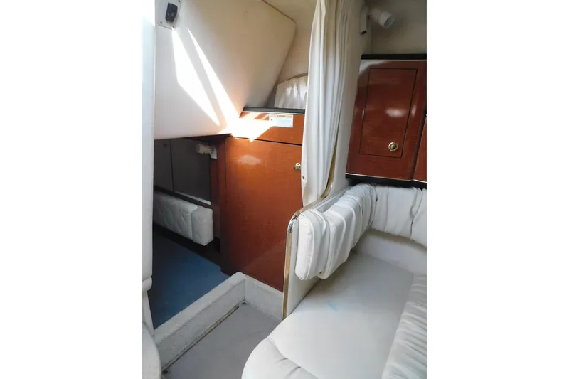 Slide: The Image of Interior of 2001 Sea Ray Sundancer 280, featuring cozy seating and wooden cabinetry. - 24