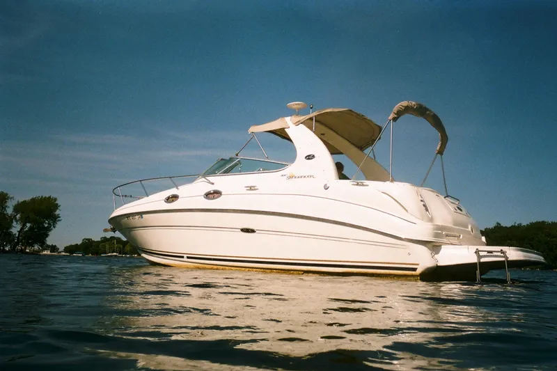 Slide: The Image of 2001 Sea Ray Sundancer 280 boat on calm water under clear blue sky. - 6