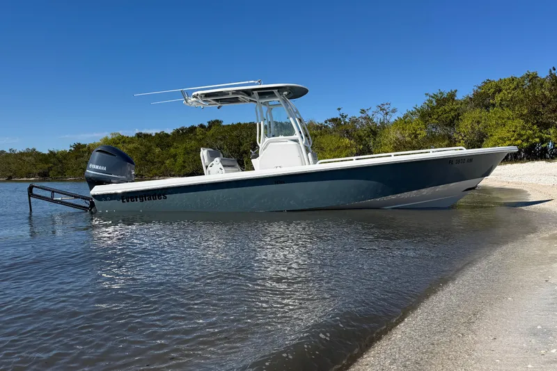 The Image of 2017 Everglades 243 Center Console boat on a sandy shore with clear blue sky. - 1
